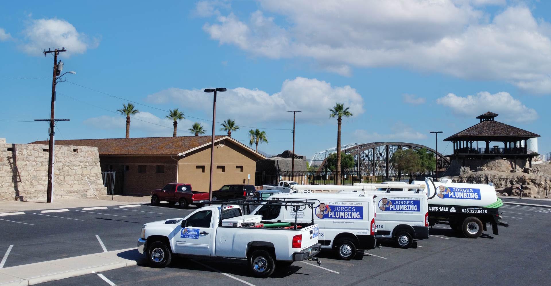 a row of Jorge's Plumbing Trucks in a Yuma Parking Lot